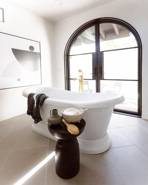  Steel doors installed in a bathroom with a standalone tub.