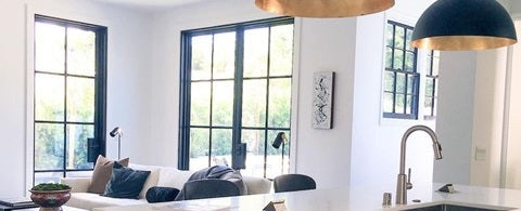 a well-lit open kitchen with steel French doors and windows