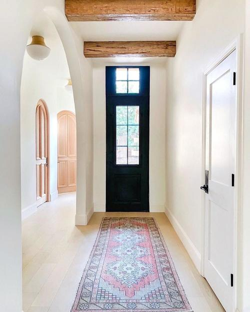 home entrance foyer with rug and an iron door with transom.