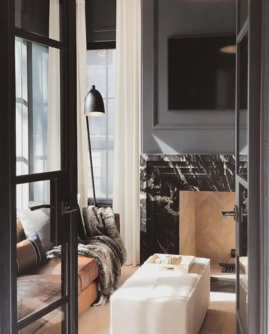 A room’s interior with black marble accents and steel doors.
