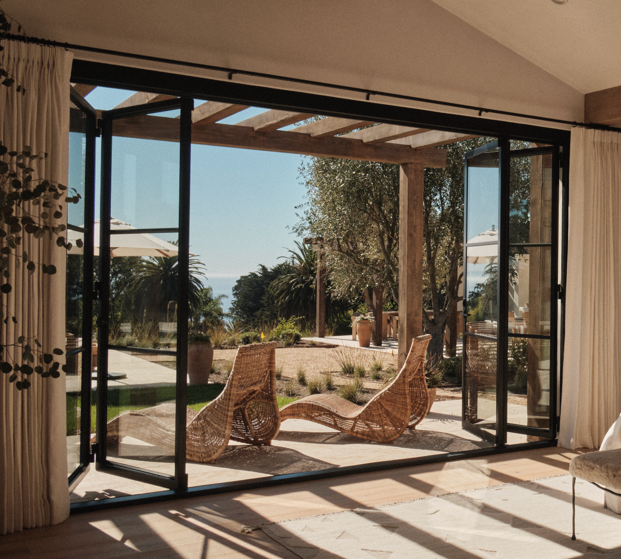 Modern steel bi-fold door with full-height glass panel and slim architectural steel frame