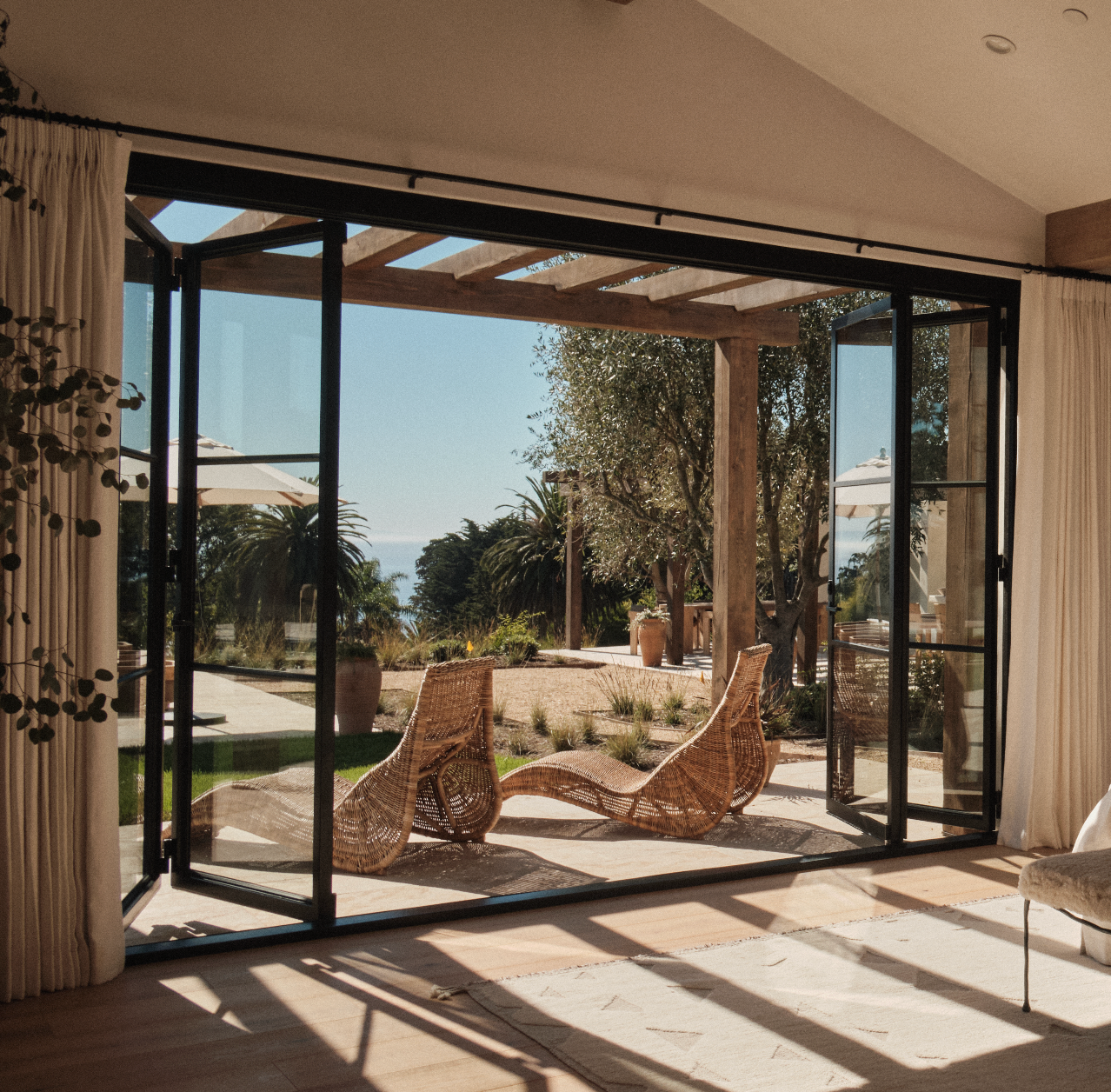 Modern steel bi-fold door with full-height glass panel and slim architectural steel frame