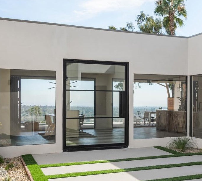 Contemporary steel pivot door with divided glass panes and minimalist design