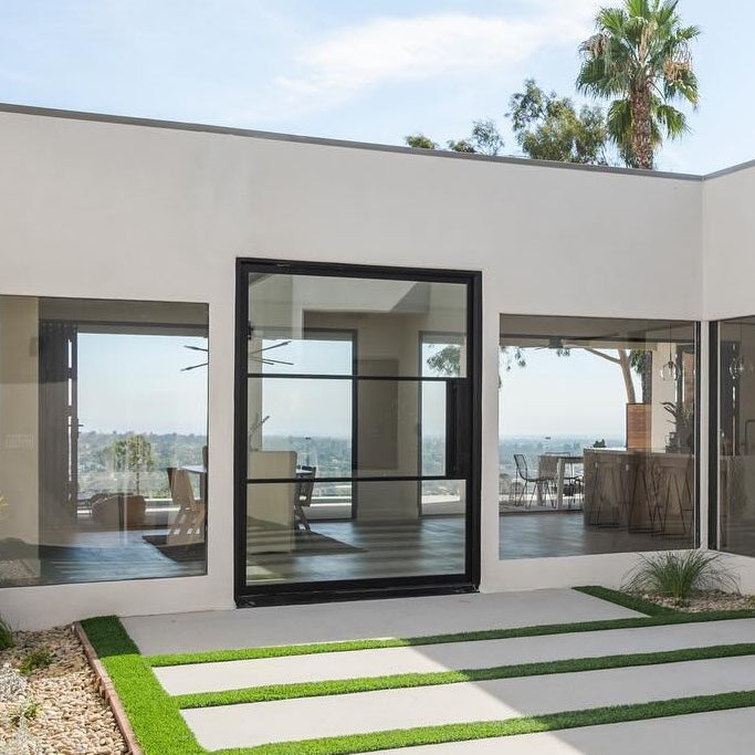 Contemporary steel pivot door with divided glass panes and minimalist design