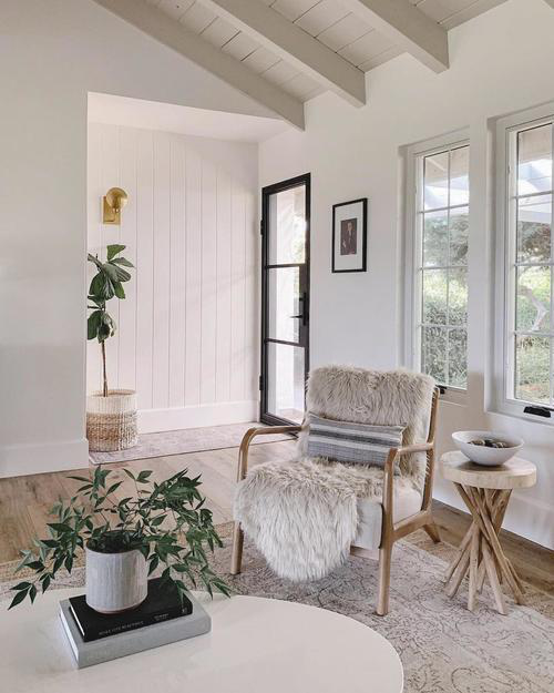 A chic room interior with white walls and a black steel door.