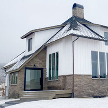 Load image into Gallery viewer, Large open pivot door on spacious house in the snow