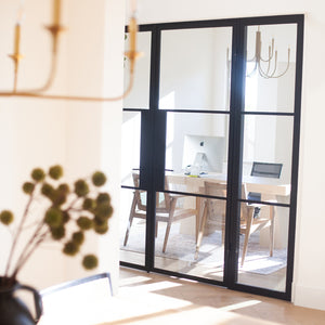 A stylish home office featuring steel doors with sidelights