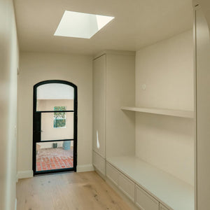 Single Arch Steel Entry Door in Hallway with Skylight