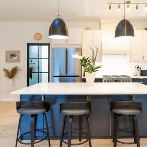 Black and white minimalist kitchen with steel door leading to laundry nook or pantry