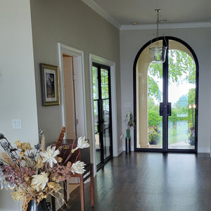 Glass and steel full arch double entry doors in elegant entry hall