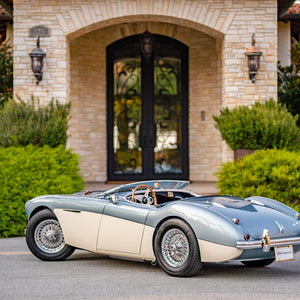 Luxury iron doors with elegant ironwork and a stylish sports car in front of an upscale home