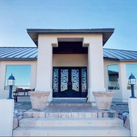 Wrought iron doors with sidelights in a sunny entry