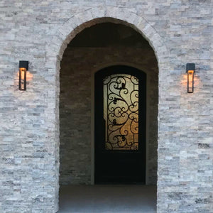 Classic style wrought iron door with glass pane in stone entryway