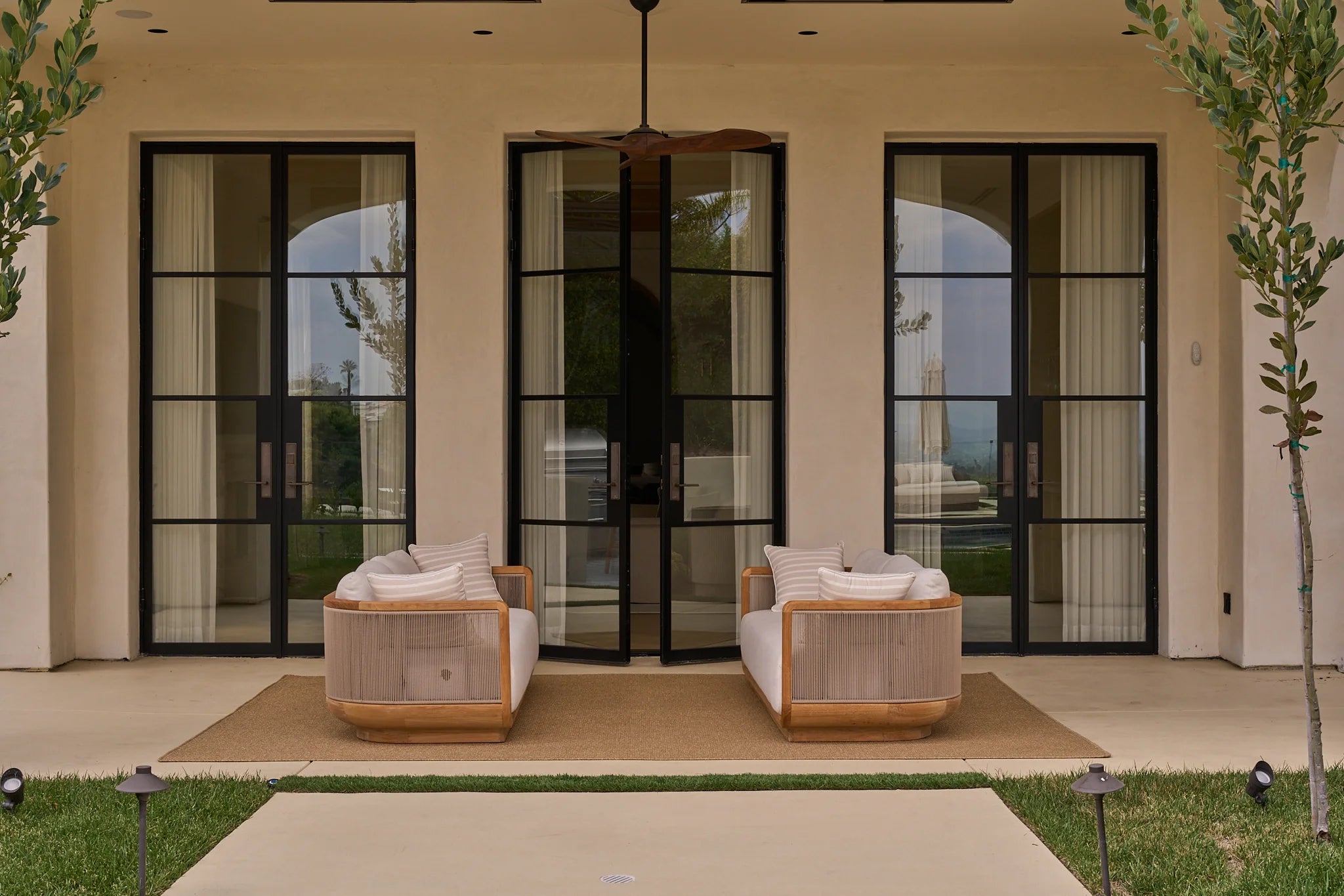 three pairs of steel french doors on the patio of a luxury home