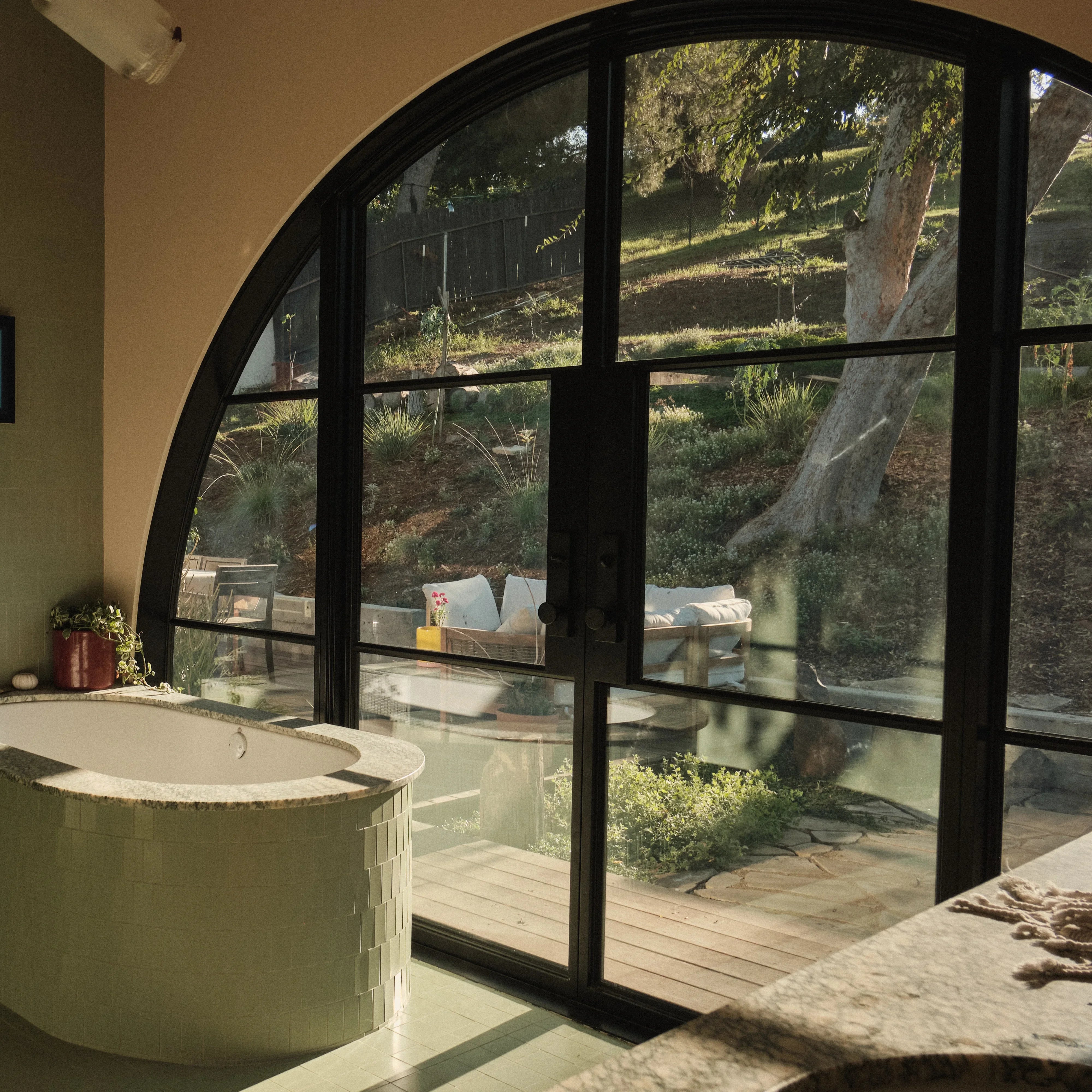 Oversized steel door with floor-to-ceiling glass and narrow steel sightlines