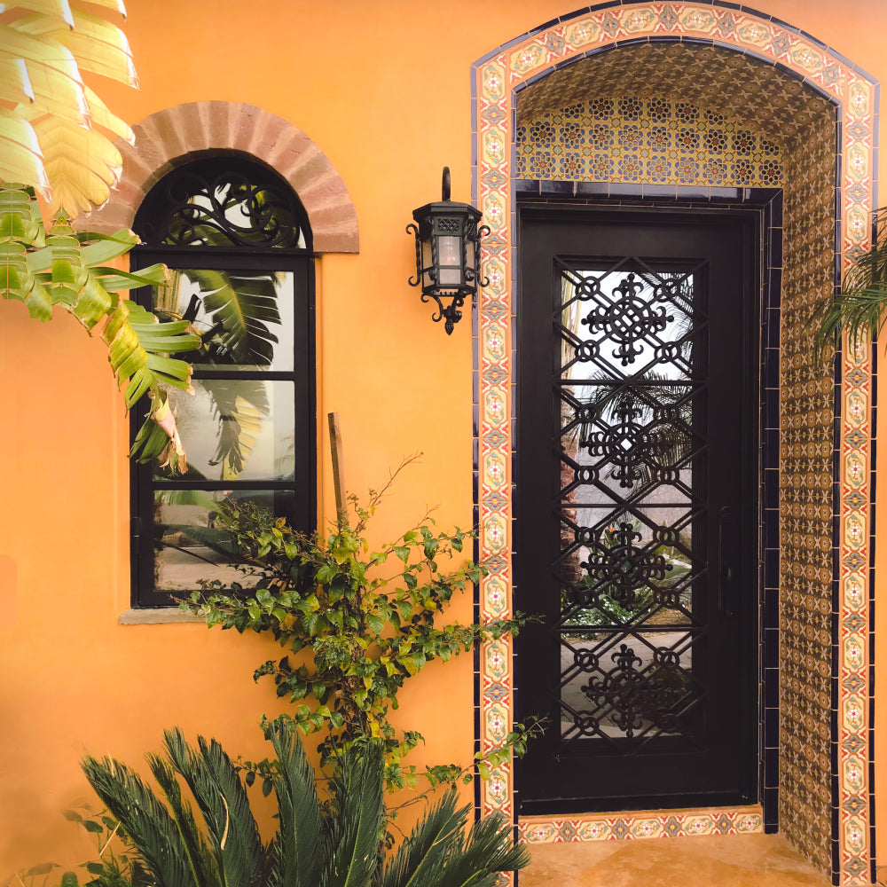 Classic single iron door with iron scrollwork in a stylish Spanish style home