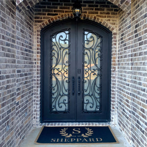 Stylish and elegant wrought iron arch topped double front entry doors in brick home