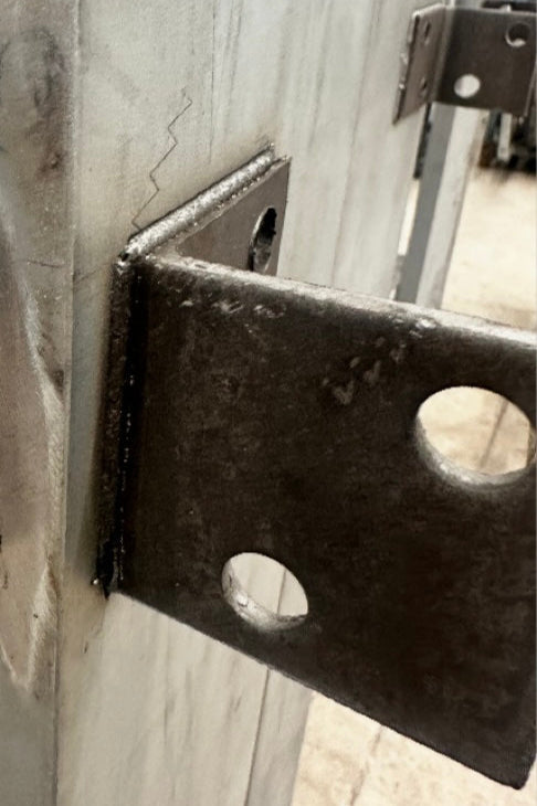 Closeup of unfinished steel door mounting tabs