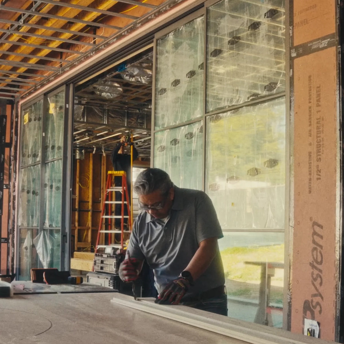 construction site where large format center split sliding steel doors are being installed