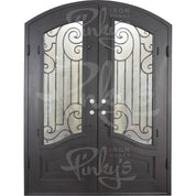 Piano bronze toned arched iron entry door with glass windows.