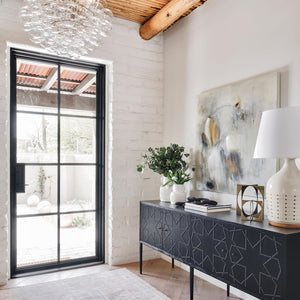 Sunny entry hall fronted with a minimal steel and glass door