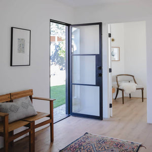 Single door made with a thin iron frame featuring two thin horizontal bars across a full length glass panel. Door is thermally broken to protect from extreme weather.