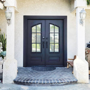 Double doors for an entryway made of iron and steel with 8-pane glass windows on top which come together in a slight arch. Doors are thermally broken to protect from extreme weather.